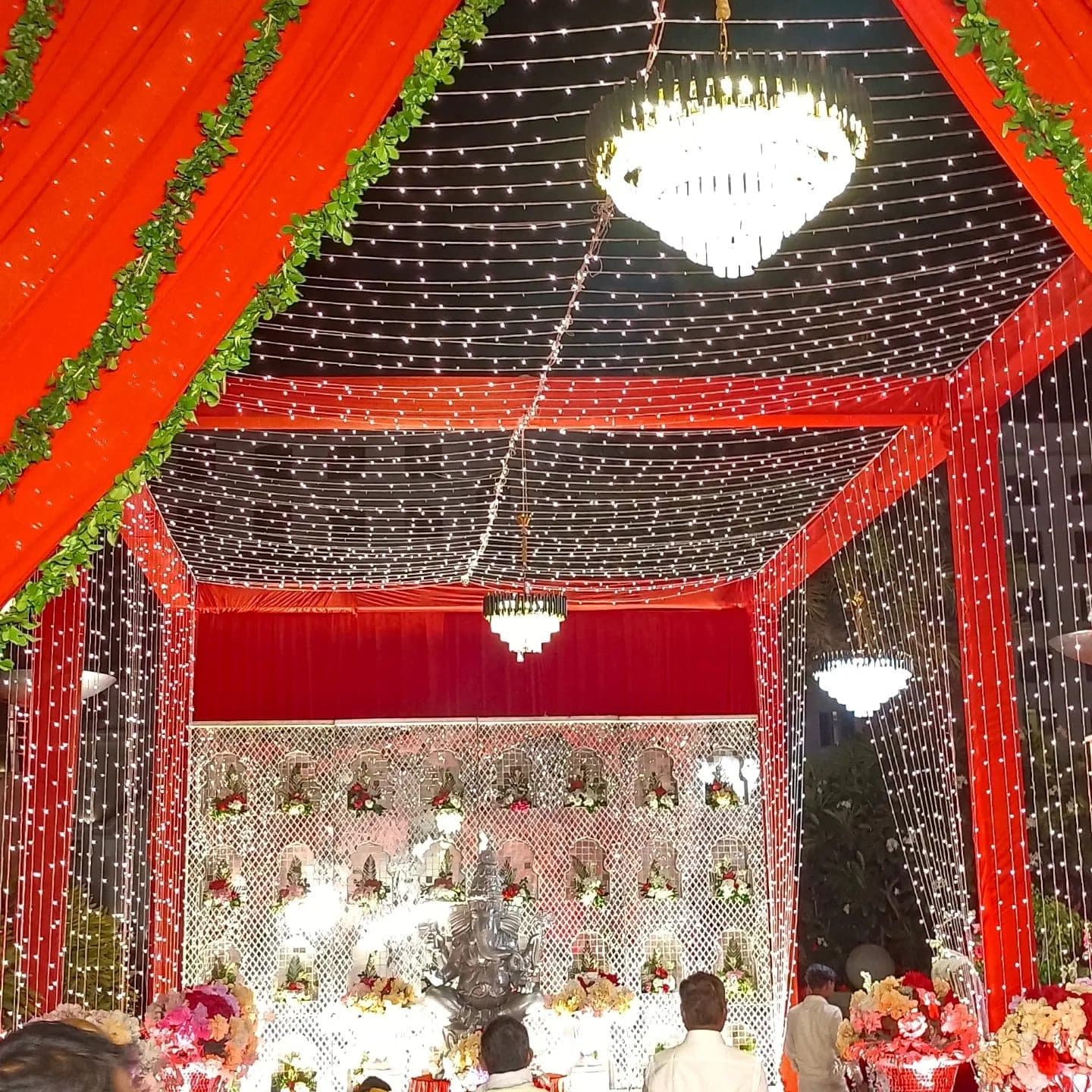 Wedding mandap with silver drapery and floral arches