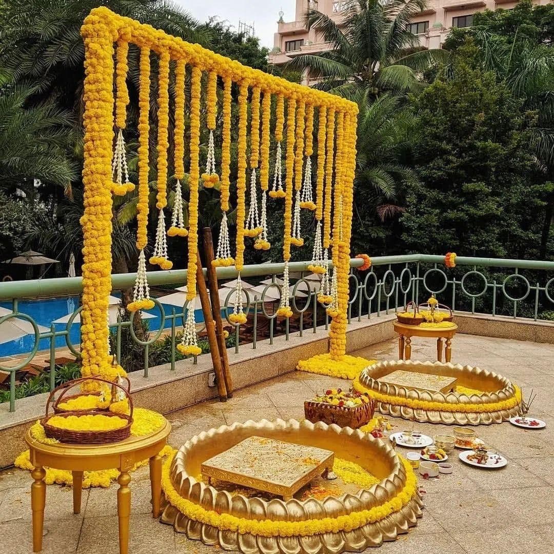 Poolside wedding mandap with yellow floral hanging arch